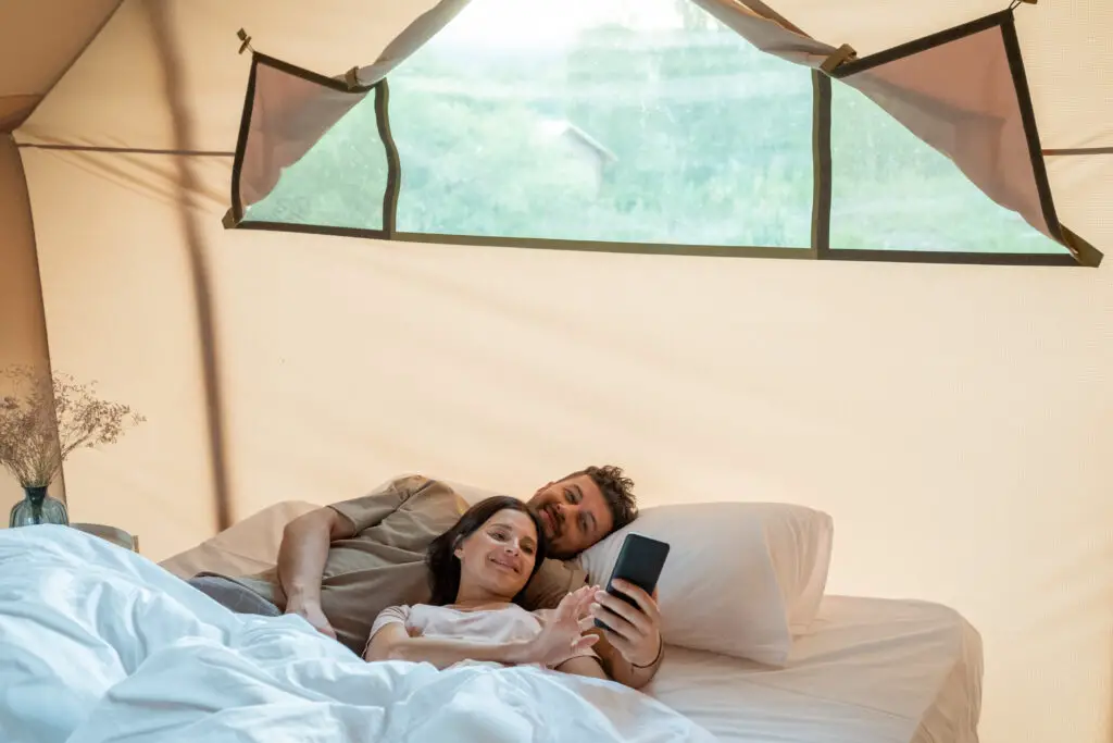 Happy couple making selfie or watching video in smartphone