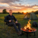 David King sitting by a campfire at sunset